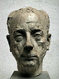Modern-style sculpture of a clean-shaven older man with receding, short hair.