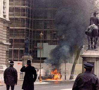 Police officers looking at a burned van used by the IRA in the 1991 mortar attack on 10 Downing Street