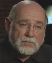 a tight headshot of an older man, he is light skinned, balding, with a beard and glasses