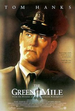 The words Tom Hanks, a prison guard looking to the distance, below the words The Green Mile, in the middle of the words, a small silhouette of a big man and small man walking towards a light.