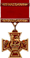 A bronze cross pattée bearing the crown of Saint Edward surmounted by a lion with the inscription Pro Valore. A Bar crosses the crimson ribbon attached to the medal.