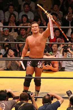 2006 winner Masato Tanaka hoists the ceremonial Fire Sword
