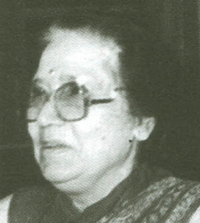 An older South Asian woman, wearing glasses.