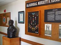Een buste van Edson naast een uitstalling van zijn medailles en foto's