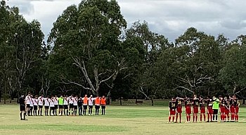 Old Xaverians SC (left) and Plenty Valley Lions FC (right) observing a minute silence before a Victorian State League Division 4 Reserves match at Hays Paddock, 27 April 2019 Oldxaviersc27april2019.jpg