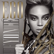 The front face of Beyoncé, in grayscale. She is wearing heavy make-up and has her hair folded back. A metallic cape is wound around her neck, which she holds at her front. Her right hand is empty, but on her left hand she wears a metallic glove. On the right of the image, the words "Ego" and "Beyoncé" are written in capital fonts. The word Ego and Knowles' cape is colored gold.