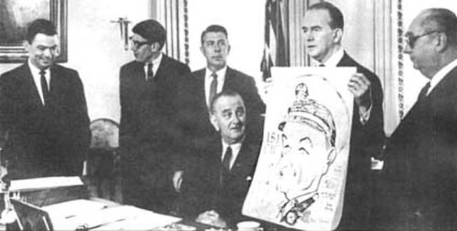 During the 1960s, cartoonists of military comic strips visited the White House. L to r: Bill Mauldin, Don Sherwood, Mort Walker, Lyndon B. Johnson, Mi