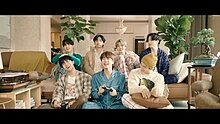 Scene from the "Life Goes On" music video depicting BTS passing time together in their shared dorm playing videogames while living in isolation during the COVID-19 pandemic BTS Life Goes On MV.jpg