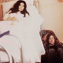 Yoko Ono in bed with John Lennon on the floor to the right. There is no text on the cover.