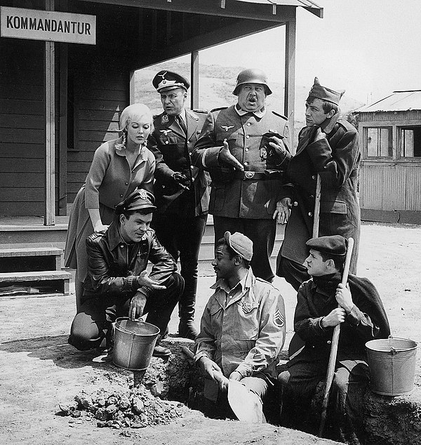 First season cast (l-r): Cynthia Lynn, Bob Crane, Werner Klemperer, John Banner, Ivan Dixon, Robert Clary, and Richard Dawson. Absent: Larry Hovis