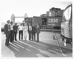 In the 1970s a 3750 toured Europe in three French lorries: a demonstration-suite lorry, a system lorry, and a generator lorry. Here potential customers flocked over several days to St Katherine's Pier near the Tower Bridge in London. The people shown were the three French lorry drivers and five IBM UK staff. IBM 3750 Switching System mobile demonstration London 1970s.jpg