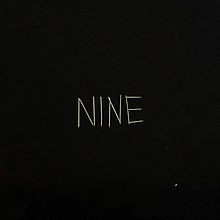 A black background with matchsticks spelling out "NINE" on it