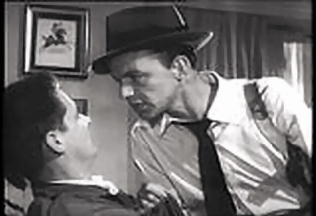 Frank Sinatra as John Baron, berating a hostage.