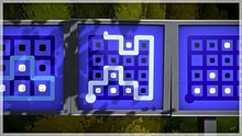 A puzzle in The Witness, in which the player must separate fields with white from those with black dots while tracing a single path through the maze. This puzzle is part of a sequence of puzzles (seen on the left and right) that teach this mechanic to the player. The Witness gameplay screenshot.jpg