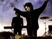 Robert Smith and Roger O'Donnell (background) in the music video shot in studio to replicate the cliffs of Beachy Head in reference to the song's lyrics. JustLikeHeavenScreenshot.jpg
