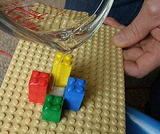 Water being poured over a Lego surface.
