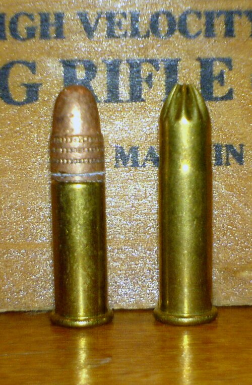 A regular Winchester .22 LR cartridge (left), with a star-crimped .22 Long Rifle snake shot cartridge loaded with No. 12 shot (right).