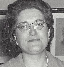 Hitam dan putih dekat potret seorang wanita yang mengenakan kacamata