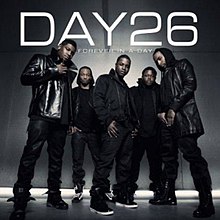 The cover shows the group standing in a grey room, wearing various black clothing. The group's name and the album title appear behind them in white lettering.