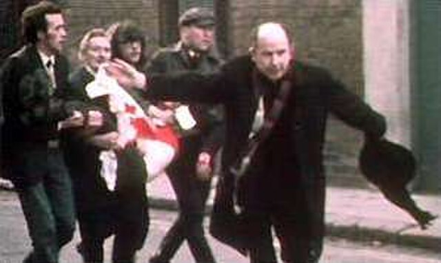 The Catholic priest Edward Daly waving a blood-stained white handkerchief while trying to escort the mortally wounded Jackie Duddy to safety