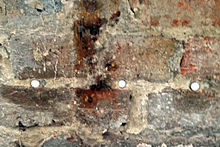 Damp-proofing rods installed along a mortar course to treat rising damp by forming a damp-proof course (DPC) Damp rods in wall.jpg