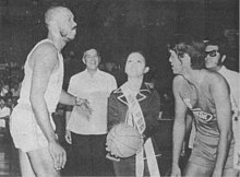 Ms. PBA, Mia Montemayor tosses the ceremonial ball between Mariwasa's Cisco Oliver and Concepcion's Ramon Lucindo during the opening ceremonies of the Philippine Basketball Association on April 9, 1975. Looking on are PBA commissioner Leo Prieto and PBA president Emerson Coseteng. PBA Inaugural Ceremonial Toss 1975.jpg