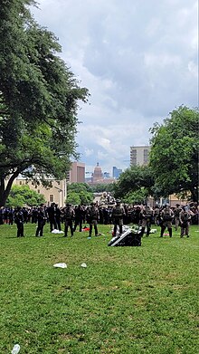 Police units separating observers from protestors on the main lawn of the University of Texas at Austin. The Texas State Capitol can be seen in the distance. Protest Image UT Austin (3).jpg