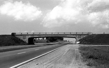 Black and white image of a bridge crossing a highway