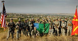 Vermont National Guardsmen supporting Operation Rising Phalanx stand with U.S. and Macedonian troops holding the Green Mountain Boys battle flag in North Macedonia GMBvngMacedonia.jpg