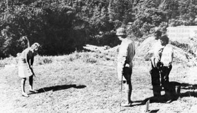 A Rhodesian couple plays golf, attended by their native caddies. Taken from a 1970 Rhodesian government booklet promoting white immigration, titled "T