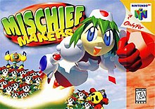 A female robot made of white, 3D spherical polygons is blasting towards the right side of the box art, with fist outstretched and a trail of fire behind her. On the ground is a legion of identical, sad-faced creatures. The logo is in big, green bubble letters, and the Nintendo 64 sidebar flanks on the right.