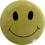 A badge bearing a smiley, a symbol of the 1980s acid house scene in the UK Smiley badge.jpg