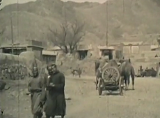 Ein Schwarz-Weiß-Bild von zwei Männern, die um 1929 eine Straße in Kalgan, China, entlanggehen.