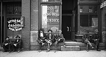 Men lounging outside a saloon and a Chinese laundry, 1910 SLC, 1910.jpg
