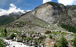 Debris from the 1991 Randa rockslides with the channel cut for the Mattervispa river at the toe. The lower part of the rockslide source region is visible on the cliff above. Randa-base-pano.jpg