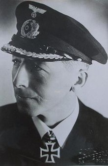 Een zwart-witfoto van een man in een militair uniform met een ijzeren kruis.