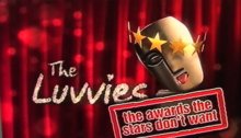 A computer generated image of an awards trophy similar to the BAFTA statuette. The trophy is an askew gold face, with a halo of golden stars and its tongue sticking out. It is in front of a glitzy red curtain. The words "The Luvvies" are spelled out in a glittery font to the left of the trophy, and the words "the awards the stars don't want" are rubberstamped in a red font to the bottom-right corner of the image.