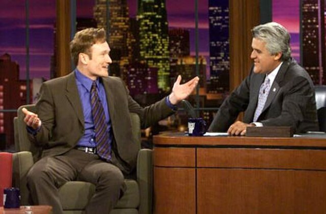 Late-night talk show hosts Conan O'Brien (left) and Jay Leno talk on the set of The Tonight Show in 2004.