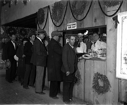 Line of unemployed men getting meals at dining hall run by McPherson, 1932.