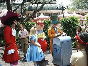 Disneyland's Push the Talking Trash Can gets a hands-on examination by Captain Hook, Alice, Tweedledum and The Mad Hatter near the entrance to Tomorrowland. Building in the background is the Plaza Inn restaurant at the edge of Main Street, U.S.A. Push with characters.jpg