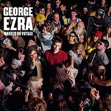 George Ezra kijkt naar de camera, staande in het midden van een overvolle kamer.  Zijn naam en de albumtitel staan ​​in de bovenhoek, in grote witte letters.