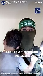 Screenshot: Militant holding Israeli children during Holit massacre Hamas militant holding toddler and baby.jpeg