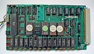 The Microtan 65 Tanex board. The EPROM chip with the green spot (centre) contains the XBUG monitor extension, the other three EPROMs the Microsoft Extended BASIC. The bottom row of chips are the 7K static RAM - 14 X 2114. The 6522 VIA is at left, with an empty socket for an additional 6522 alongside. The empty green socket at top centre is for the 6551 UART. Tangerine Microtan 65 Tanex Board.jpg