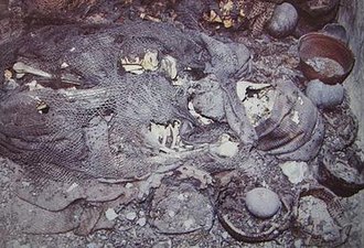 Burial I, a corpse at the F-12:B-2 tomb in La Galgada. Archaeologists have established the figure to have been a male over the age of fifty, who was flexed on his right side. Surrounding him are cotton bags, baskets and gourd vessels that have been deposited as offerings. La Galgada corpse.jpg