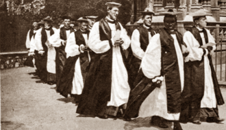 Lunga processione di sacerdoti per lo più bianchi in costume episcopale