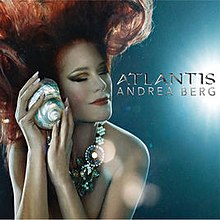 Рыжеволосая женщина под водой с закрытыми глазами. На ней блестящее жемчужное ожерелье. Она прижимает к щеке моллюсков. Слова «Андреа Берг Атлантида» написаны серебром справа.
