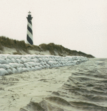 The Cape Hatteras lighthouse stands behind a seawall of sandbags that temporarily stabilized the eroding shore; wave action destroyed the seawall soon after it was built. Lighthouse.gif