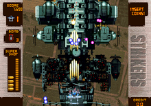 Arcade version screenshot, showing a P-38 Lightning engaging in a battle against Battle Air Ship Iron Casket. NEOGEO Strikers 1945 Plus.png