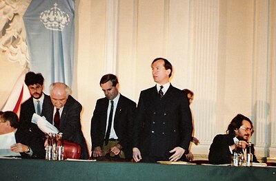 ヨーロッパ君主主義者会議、ワルシャワ、1990 年 12 月 8 ～ 9 日。グレゴリー ローダー フロスト スタンディング センター、ポール ベノワ カナダ ML の副会長が彼の右側に、ブルガリア君主主義者・保守連合のイヴァン マルチェフスキーが彼の左側に座っています。