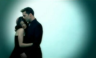 A screenshot from the music video, depicting Martin and Charlotte Ayanna as lovers hugging each other romantically in a flashback.